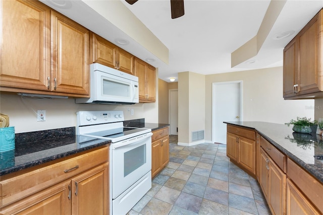 39 Bunker Pl, Rotonda West, FL 33947 - kitchen featuring dark stone countertops, visible vents, white appliances, stone finish flooring, and baseboards