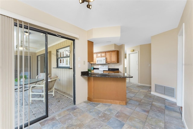 39 Bunker Pl, Rotonda West, FL 33947 - kitchen featuring white appliances, baseboards, a peninsula, stone finish floor, and visible vents