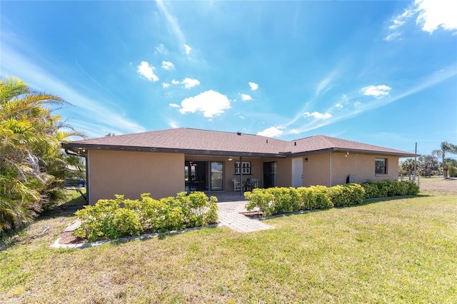39 Bunker Pl, Rotonda West, FL 33947 - back of property with a patio area, a lawn, and stucco siding
