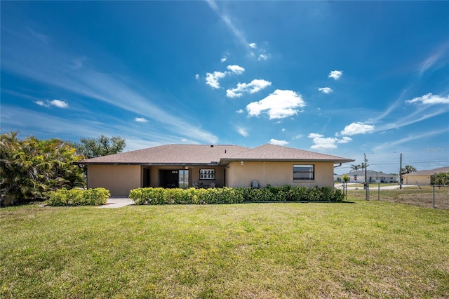39 Bunker Pl, Rotonda West, FL 33947 - view of front of property featuring a front lawn, stucco siding, and fence