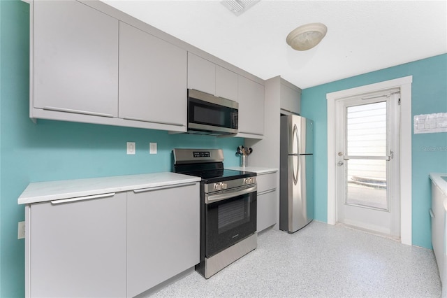 1245 Gulf Blvd, Englewood, FL 34223 - kitchen with visible vents, light countertops, appliances with stainless steel finishes, and gray cabinetry