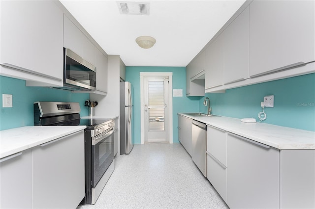 1245 Gulf Blvd, Englewood, FL 34223 - kitchen with appliances with stainless steel finishes, a sink, gray cabinets, light speckled floor, and visible vents