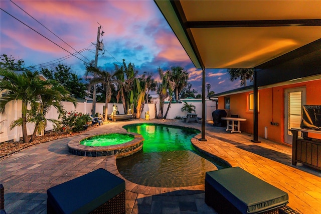 1245 Gulf Blvd, Englewood, FL 34223 - pool at dusk with a patio, a pool with connected hot tub, and a fenced backyard