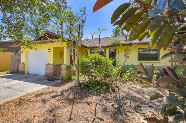 ranch-style home with stucco siding, driveway, and a garage