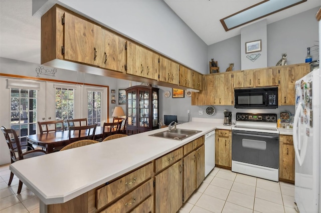 kitchen with high vaulted ceiling, a sink, white appliances, and light tile patterned floors