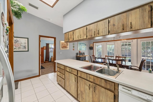 kitchen featuring a sink, visible vents, white dishwasher, light countertops, and light tile patterned floors