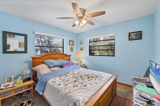 bedroom featuring a ceiling fan, baseboards, and dark carpet