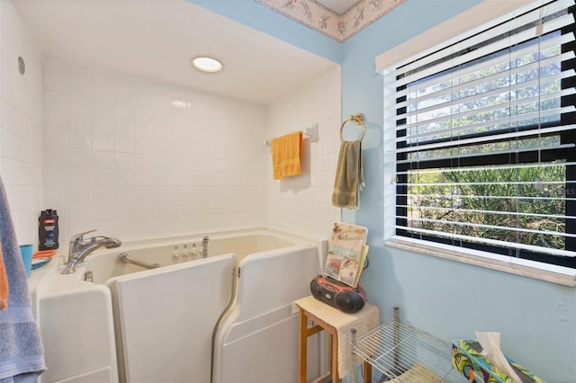 bathroom featuring a healthy amount of sunlight and a garden tub