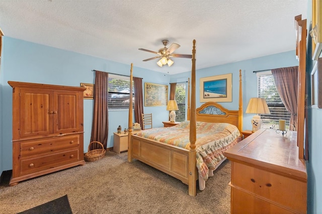 carpeted bedroom featuring a ceiling fan and a textured ceiling