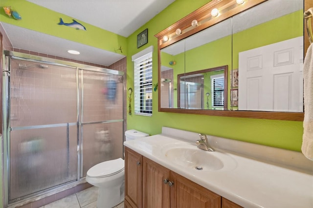 full bathroom featuring vanity, toilet, a stall shower, and tile patterned floors