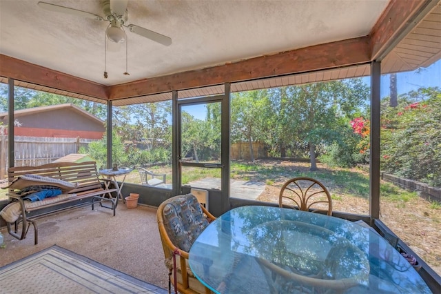 sunroom / solarium with outdoor dining area and ceiling fan