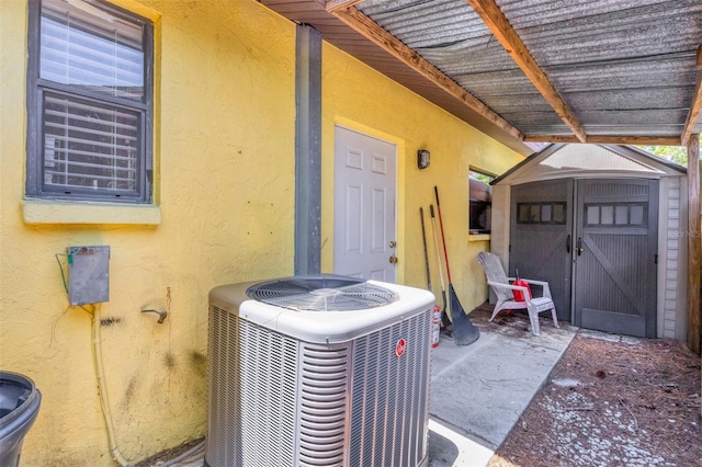 view of exterior entry with stucco siding and central AC unit