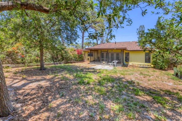 back of house featuring a sunroom, a patio, and fence