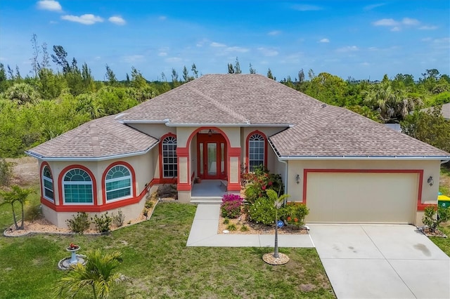 mediterranean / spanish-style house with an attached garage, a front lawn, stucco siding, and roof with shingles