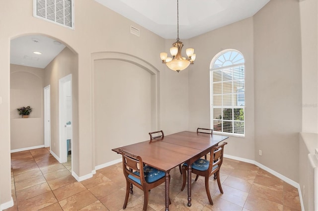 dining area featuring light tile patterned floors, a notable chandelier, arched walkways, and visible vents