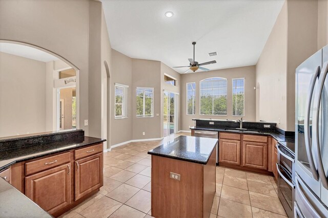kitchen with a sink, a ceiling fan, visible vents, a kitchen island, and appliances with stainless steel finishes
