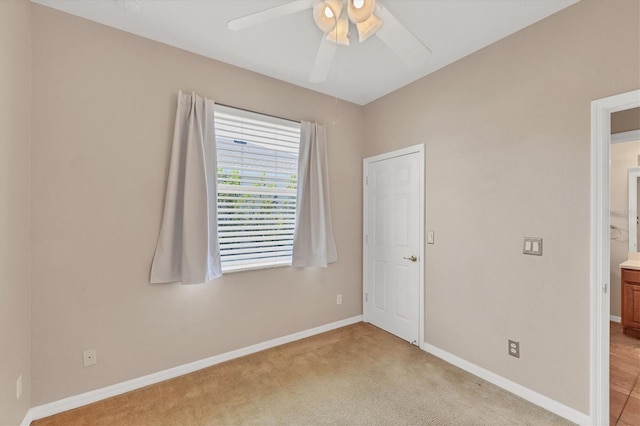 unfurnished bedroom with baseboards, a ceiling fan, and carpet