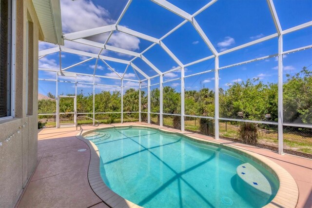 outdoor pool with a patio and glass enclosure