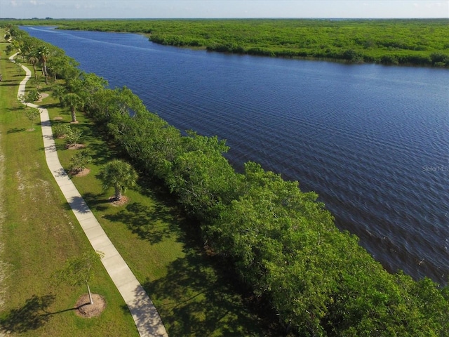 birds eye view of property with a water view and a wooded view