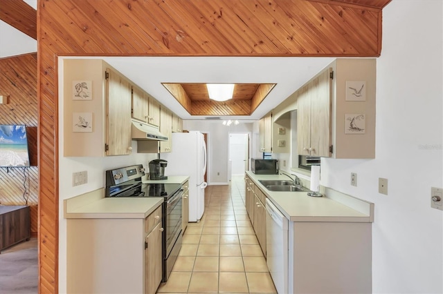 kitchen featuring range with electric stovetop, under cabinet range hood, white dishwasher, wood walls, and a sink