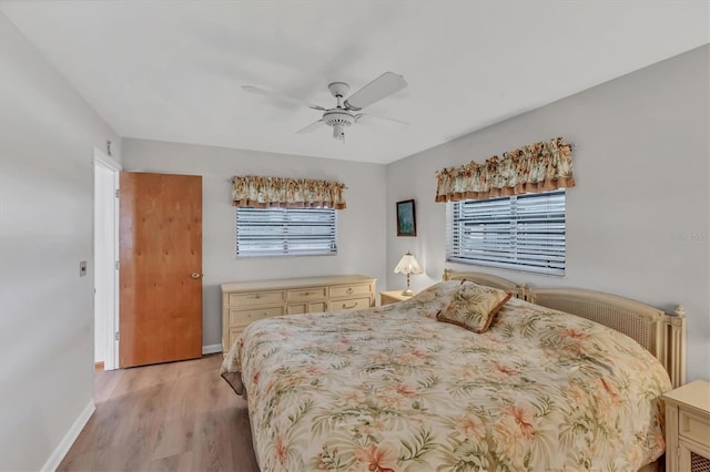 bedroom featuring baseboards, light wood-type flooring, and ceiling fan