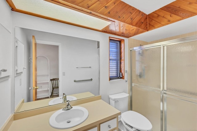 bathroom featuring a shower stall, toilet, and vanity