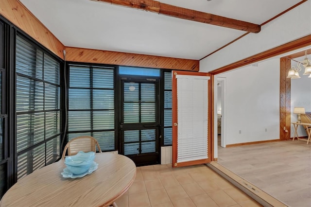 interior space with light tile patterned floors, beam ceiling, a chandelier, and baseboards