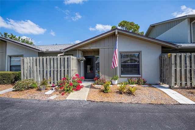 view of front of home featuring stucco siding and fence