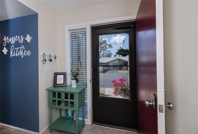 doorway featuring baseboards and tile patterned floors