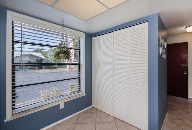 unfurnished dining area with tile patterned floors and baseboards