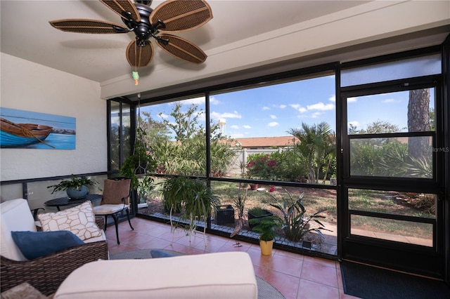 sunroom / solarium with a ceiling fan and tile patterned floors