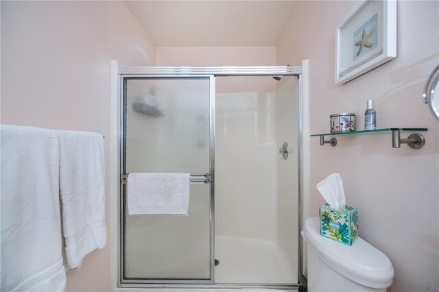 bathroom featuring a shower stall and toilet