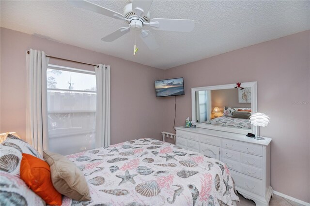 bedroom with a textured ceiling and a ceiling fan
