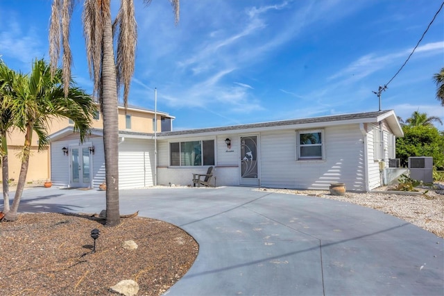 view of front of home with french doors and curved driveway