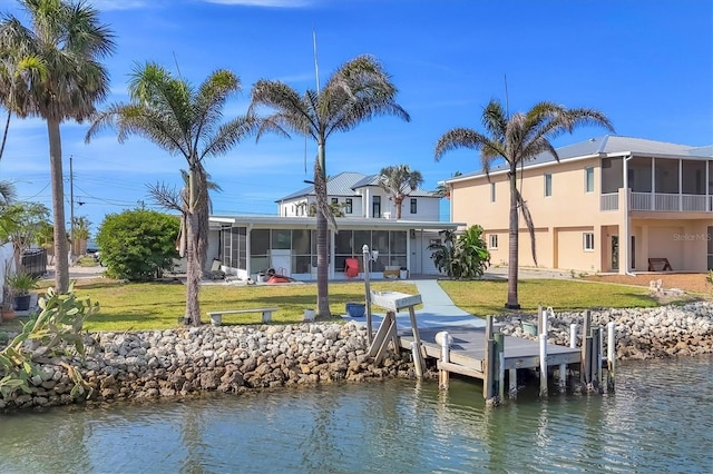 view of dock featuring a lawn and a water view