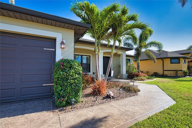 35 Medalist Rd, Rotonda West, FL 33947 - doorway to property featuring a yard, covered porch, stucco siding, and a garage