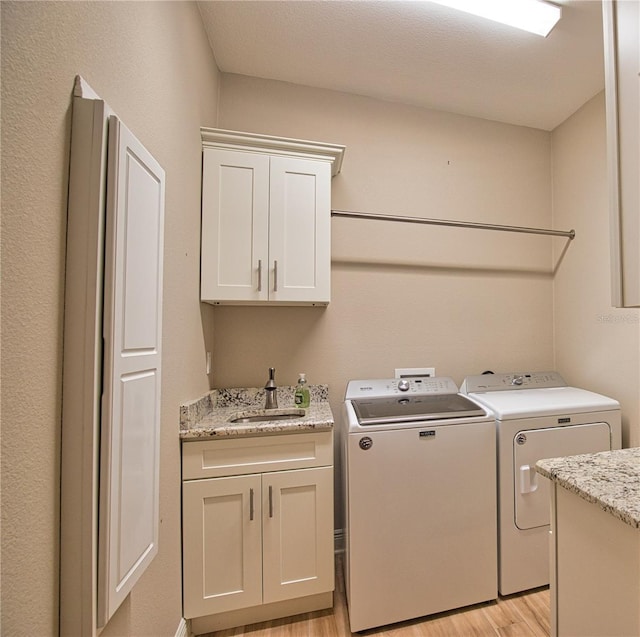 35 Medalist Rd, Rotonda West, FL 33947 - laundry area with light wood-style flooring, washer and dryer, and cabinet space