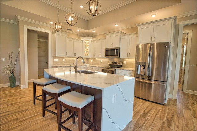 35 Medalist Rd, Rotonda West, FL 33947 - kitchen featuring stainless steel appliances, light wood-style floors, white cabinets, a breakfast bar area, and decorative backsplash
