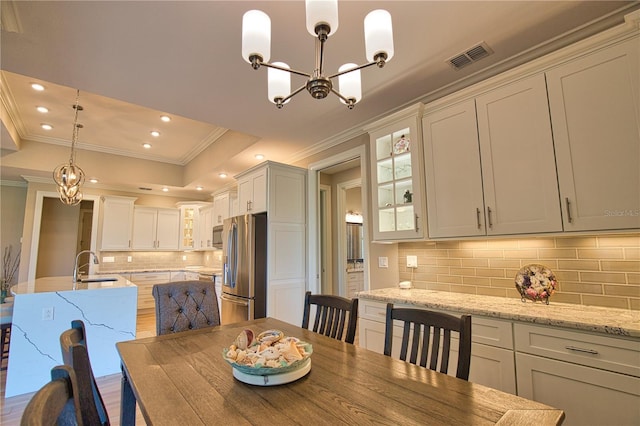 35 Medalist Rd, Rotonda West, FL 33947 - dining space with a chandelier, crown molding, a raised ceiling, recessed lighting, and wood finished floors