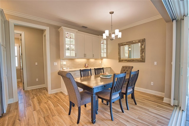 35 Medalist Rd, Rotonda West, FL 33947 - dining room with a chandelier, light wood finished floors, and ornamental molding