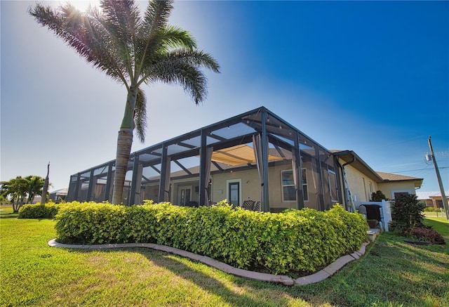 35 Medalist Rd, Rotonda West, FL 33947 - rear view of property featuring a yard, stucco siding, and glass enclosure