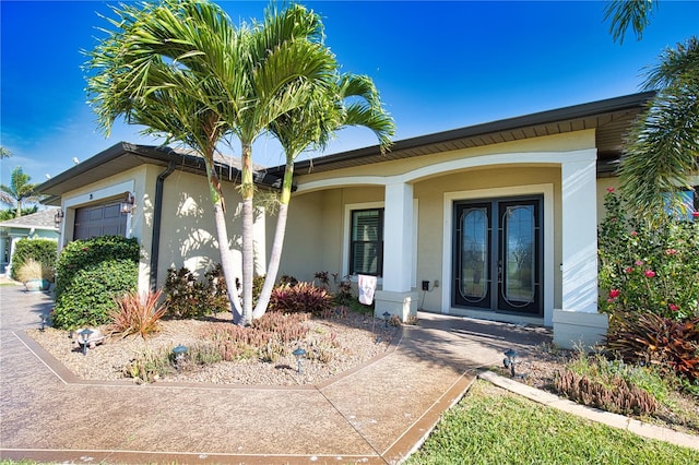 35 Medalist Rd, Rotonda West, FL 33947 - property entrance featuring stucco siding, a garage, and covered porch