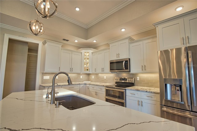 35 Medalist Rd, Rotonda West, FL 33947 - kitchen with stainless steel appliances, backsplash, glass insert cabinets, light stone counters, and ornamental molding