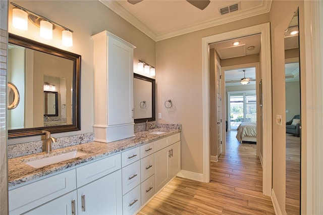 35 Medalist Rd, Rotonda West, FL 33947 - ensuite bathroom featuring a ceiling fan, double vanity, wood finished floors, and ornamental molding