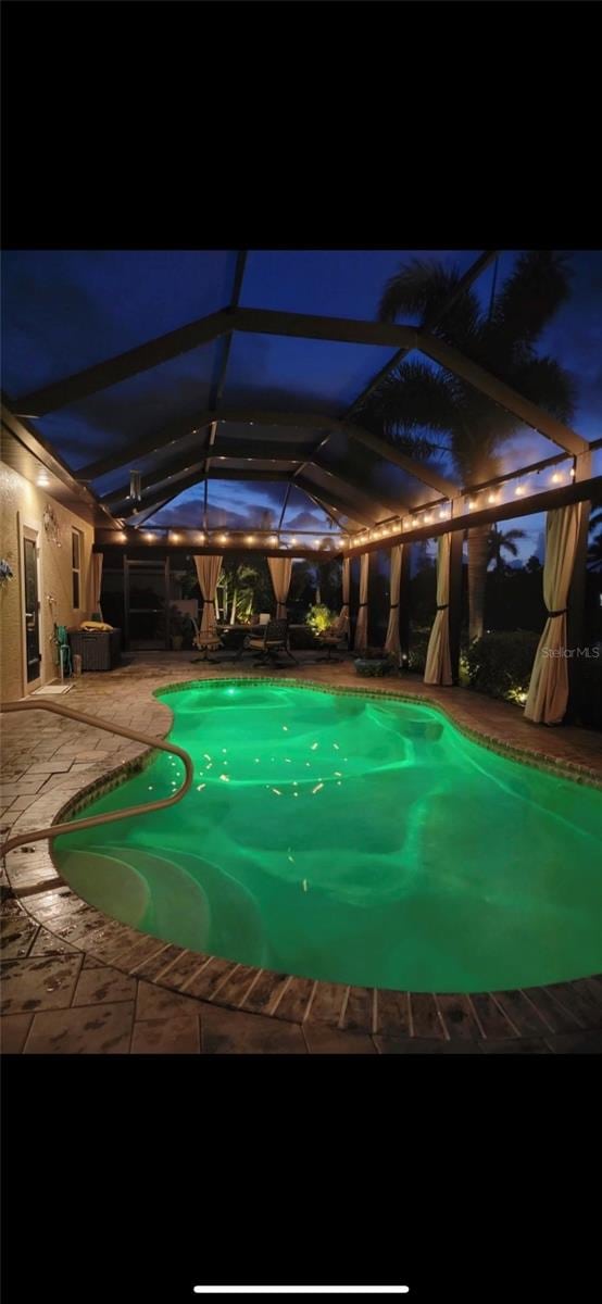 35 Medalist Rd, Rotonda West, FL 33947 - pool at twilight featuring an outdoor pool, a patio area, and glass enclosure