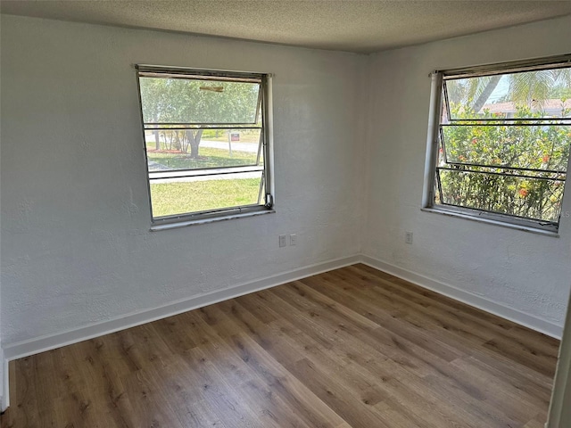 194 Garden Ave NW, Port Charlotte, FL 33952 - unfurnished room with wood finished floors, baseboards, and a textured ceiling