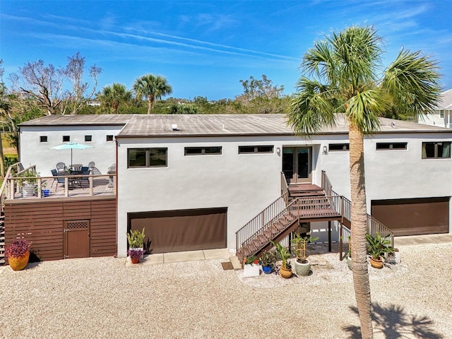 view of front of home with stucco siding, driveway, and stairway