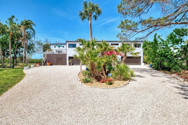 view of front of property featuring curved driveway and stairs