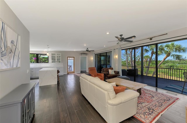 living room with dark wood-style flooring, a ceiling fan, recessed lighting, and visible vents