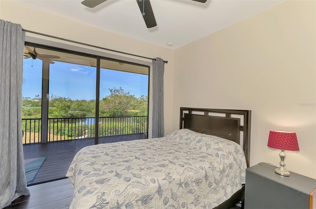 bedroom with access to outside, ceiling fan, wood finished floors, and a water view